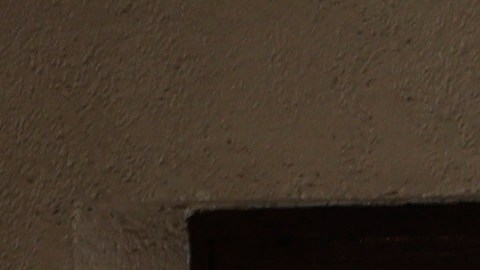Un hombre camina por un edificio cuya fachada está cubierta con estrellas de David pintadas durante la noche, en el distrito Alesia de París.