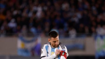 Lionel Messi de Argentina se ajusta la banda de capitán.