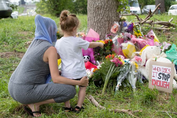 Las familias presentan sus respetos el 8 de junio de 2021 en un monumento improvisado cerca del lugar donde el hombre que conducía una camioneta atropelló y mató a cuatro miembros de una familia musulmana en London, Ontario, Canadá. (Foto de NICOLE OSBORNE/AFP vía Getty Images)
