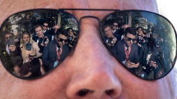 Los reporteros se reflejan en las gafas de sol del presidente estadounidense Joe Biden mientras habla con la prensa.