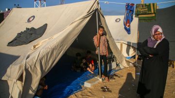 Palestinos descansan en una tienda de campaña para refugiados a lo largo de la Franja de Gaza.