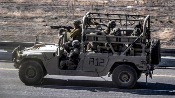 Soldados del ejército israelí sentados en un Humvee que avanza por una carretera cerca de la frontera con la Franja de Gaza.