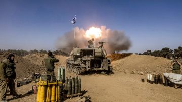 Soldados israelíes se tapan los oídos mientras un obús de artillería autopropulsado dispara rondas desde la frontera con la Franja de Gaza.