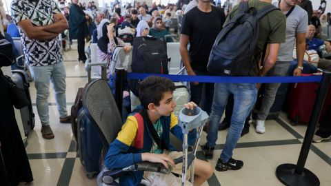 Palestinos con doble nacionalidad y extranjeros esperan cruzar el cruce fronterizo de Rafah con Egipto, en el sur de la Franja de Gaza.