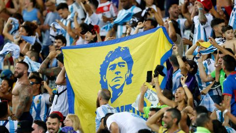 Hinchas de Argentina muestran una bandera con el retrato de Diego Armando Maradona.