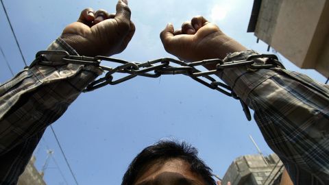 A Palestinian youth, his hands chained i