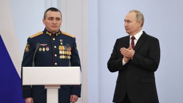 El presidente ruso, Vladimir Putin, aplaude junto al teniente coronel Alexander Zavadsky, quien murió en batalla.