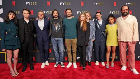 Actores de Stranger Things posando en una alfombra roja.