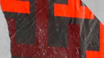 Kourtney Kardashian y Travis Barker posando en una alfombra roja.