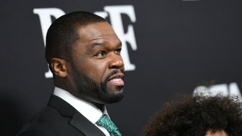 50 Cent posando en una alfombra roja.
