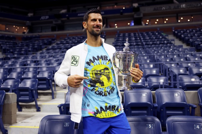 NEW YORK, NEW YORK - SEPTEMBER 10: Novak Djokovic of Serbia poses for the media with his winners trophy wearing a shirt as a tribute to the late Kobe Bryant after defeating Daniil Medvedev of Russia during their Men's Singles Final match on Day Fourteen of the 2023 US Open at the USTA Billie Jean King National Tennis Center on September 10, 2023 in the Flushing neighborhood of the Queens borough of New York City. (Photo by Clive Brunskill/Getty Images)