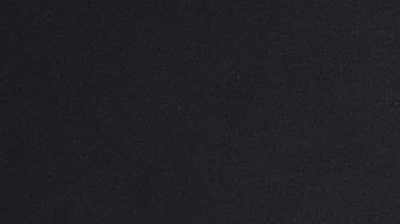 Dua Lipa posando en una alfombra roja.