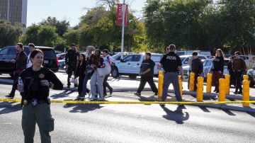 La gente cruza Maryland Parkway mientras los sacan del campus de la UNLV después del tiroteo.