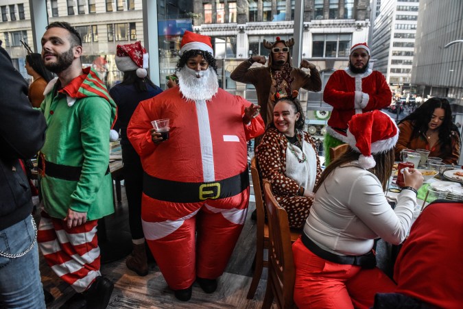 Juerguistas vestidos como personajes navideños participan en el recorrido anual por los pubs de SantaCon en la ciudad de Nueva York, aunque varios han sido señalados de incurrir en excesos. (Foto de Stephanie Keith/Getty Images)