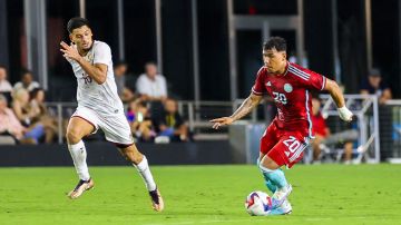 El colombiano Roger Martinez y el venezolano Renne Rivas en medio de la acción en el amistoso entre las selecciones de fútbol de sus respectivos países.