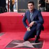 Zac Efron posando junto a su estrella en el Paseo de la Fama de Hollywood.