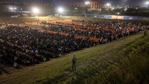 Un agente de la Patrulla Fronteriza vigila a más de 2.000 migrantes en un centro de procesamiento de campo en Eagle Pass, Texas.