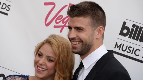 Shakira y Gerard Piqué posando juntos en una alfombra roja.