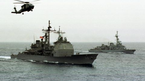 As Thick Gray Clouds Hang Overhead The Air An Hs 60 Seahawk Flies Around The USS Anzio As The U S F