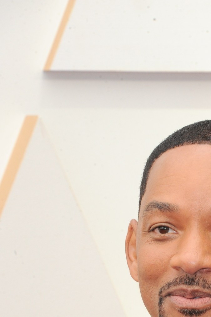 Will Smith posando en una alfombra roja.