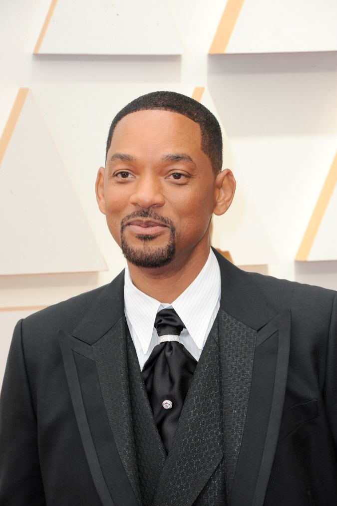 Will Smith posando en una alfombra roja.