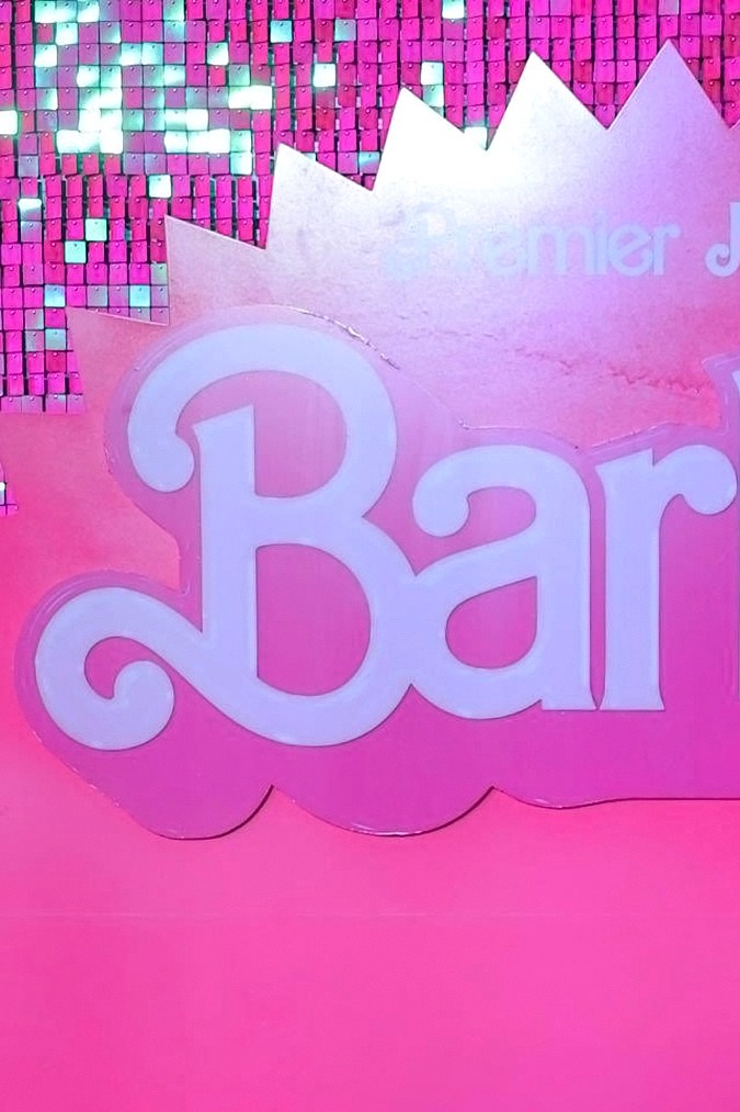 Margot Robbie y America Ferrara posando en una alfombra roja.