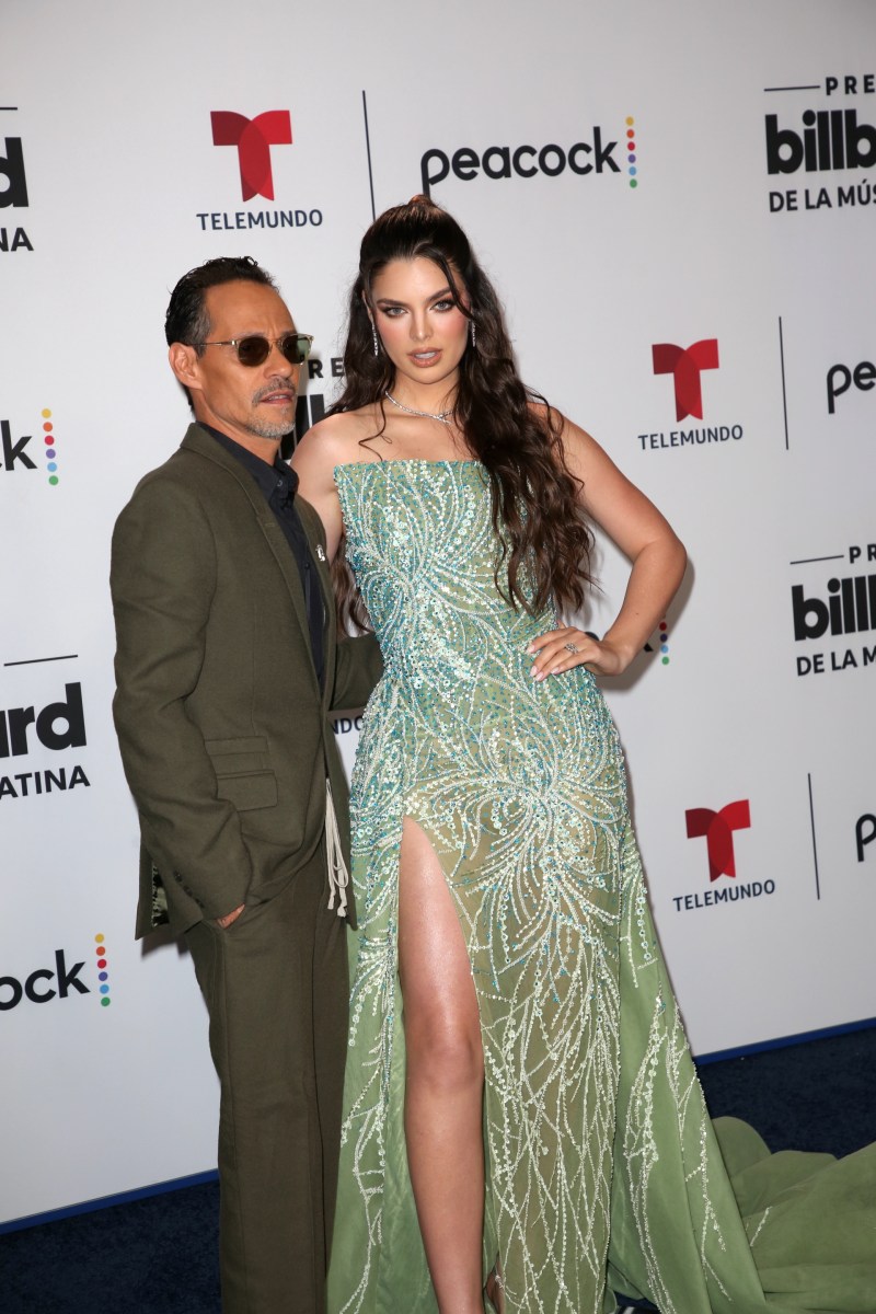 Marc Anthony y Nadia Ferreira posando en una alfombra roja.