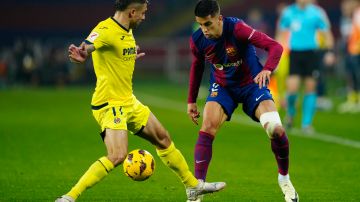 El defensa del Villarreal Francisco Femenía (i) lucha con João Cancelo, del FC Barcelona.