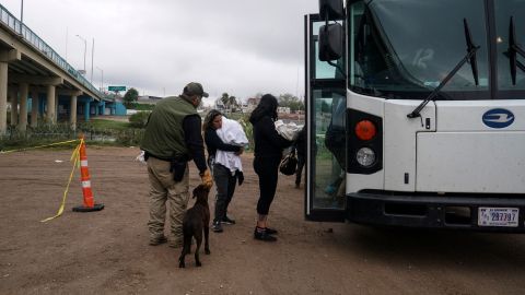 Migrantes son embarcados en un bus en Texas.