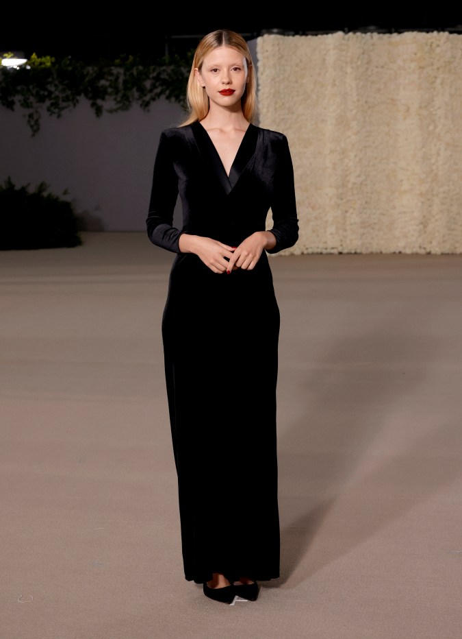 Mia Goth posando en una alfombra roja.