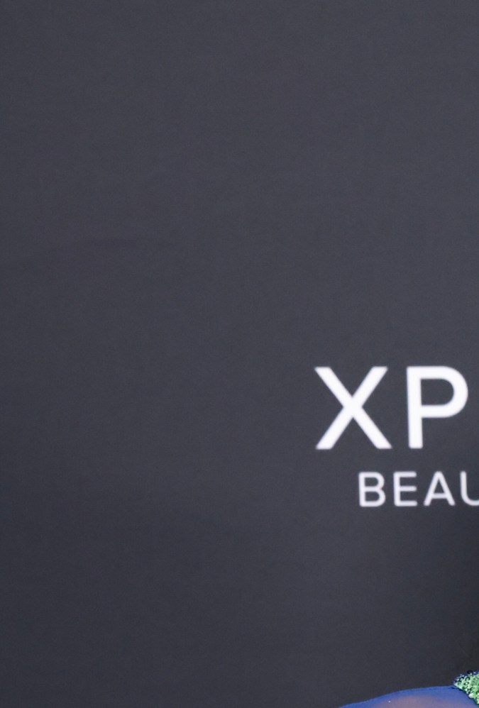 Isabela Merced posando en una alfombra roja.