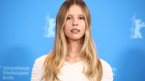 Mia Goth posando en una alfombra roja.