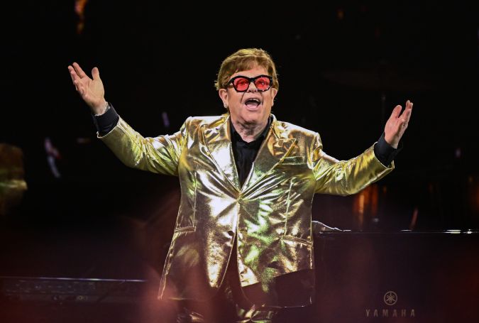 Elton John actuando en un show en vivo.