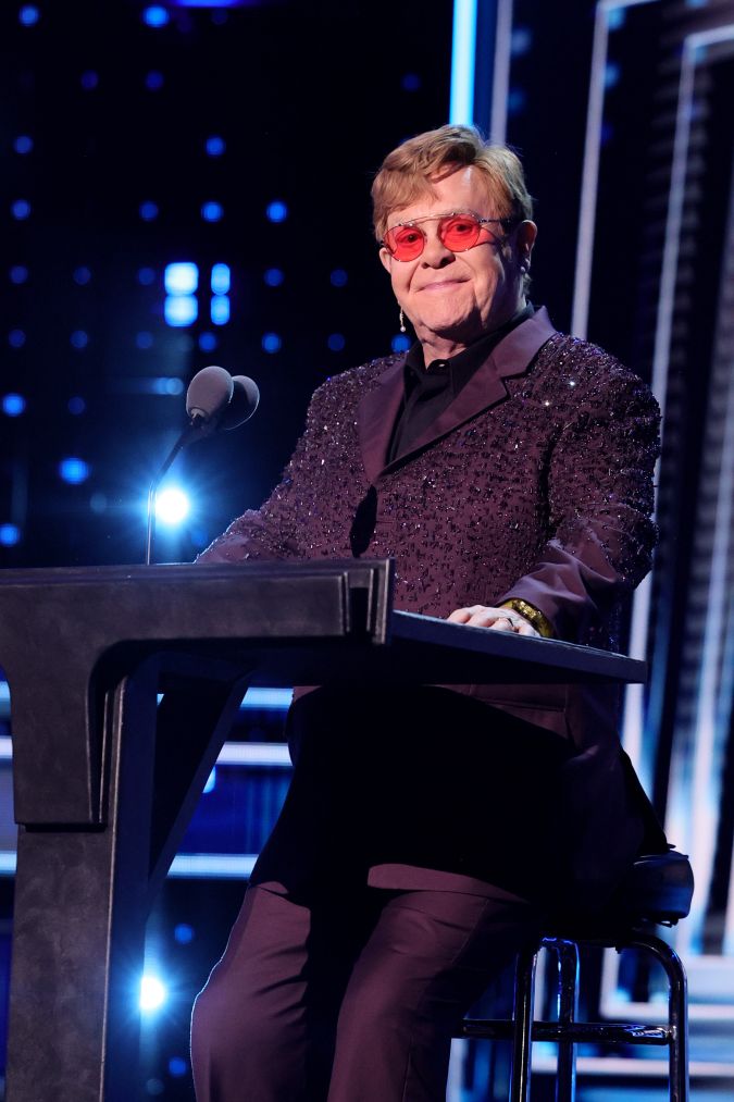 Elton John actuando en un show en vivo.