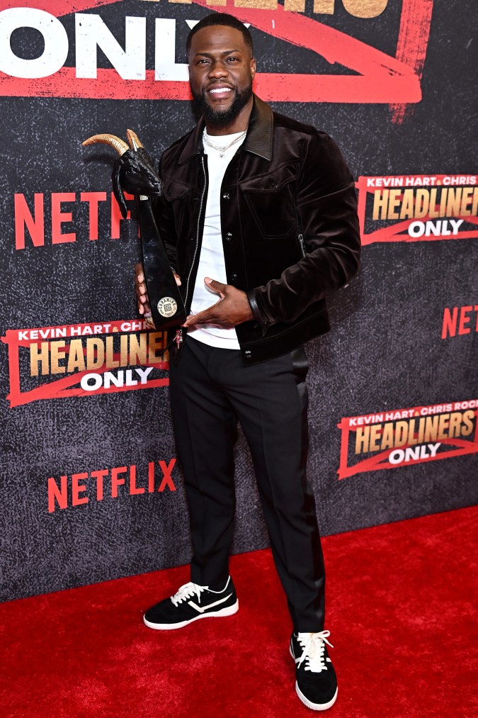 Kevin Hart posando en una alfombra roja.