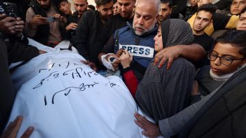 El jefe de la oficina de Al Jazeera en Gaza, Wael Al-Dahdouh, abraza a su hija mientras llora por el cuerpo de su hijo Hamza Wael Dahdouh, periodista de la cadena de televisión Al Jazeera, durante su funeral, después de que fuera asesinado en un reporte.