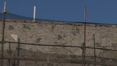 La gente camina junto a un muro con fotografías de rehenes durante una manifestación para conmemorar los 100 días que los rehenes han estado en cautiverio.