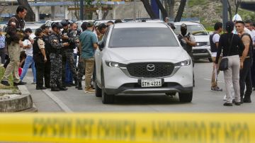 Miembros de la Policía Nacional permanecen en el lugar donde el fiscal César Suárez fue asesinado a tiros en Guayaquil, Ecuador.