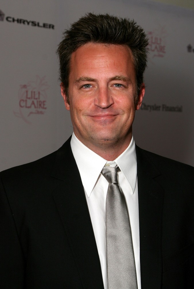 Matthew Perry posando en una alfombra roja.