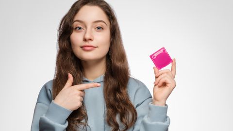 Young,Woman,,Teenager,With,A,Condom,In,Her,Hand.,Young