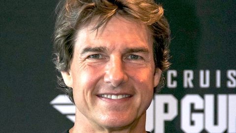 Tom Cruise posando en una alfombra roja.