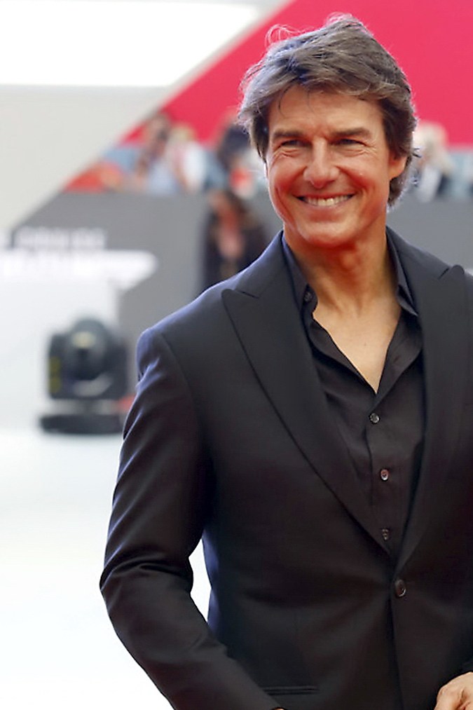 Tom Cruise posando en una alfombra roja.