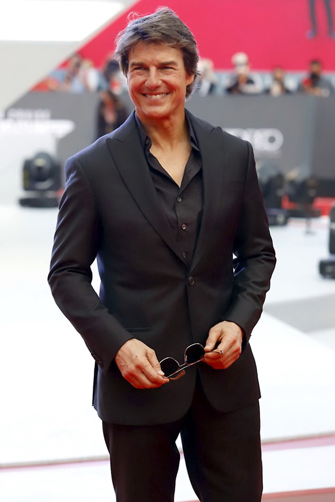 Tom Cruise posando en una alfombra roja.
