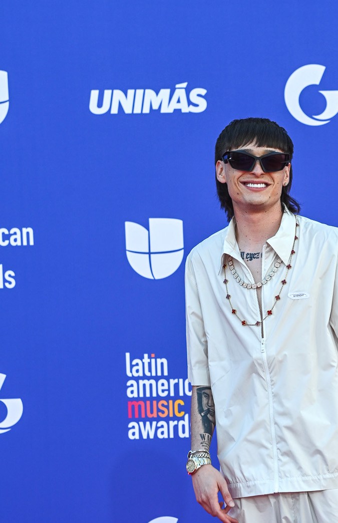 Peso Pluma posando en una alfombra roja.