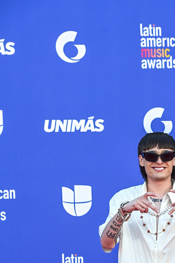 Peso Pluma posando en una alfombra roja.