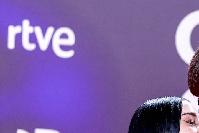 Peso Pluma y Nicki Nicole posando en una alfombra roja.