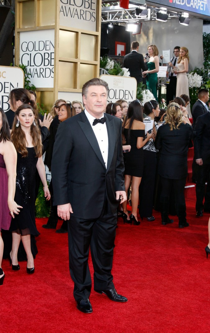 Alec Baldwin posando en una alfombra roja.