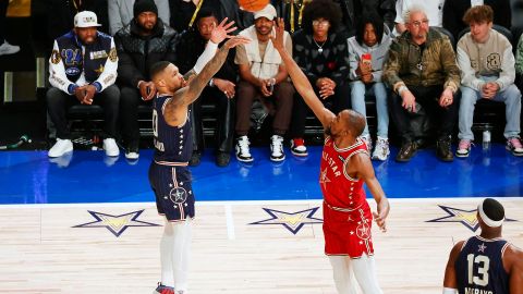 Damian Lillard (I) lanza un tiro de tres puntos frente a Kevin Durant (D).