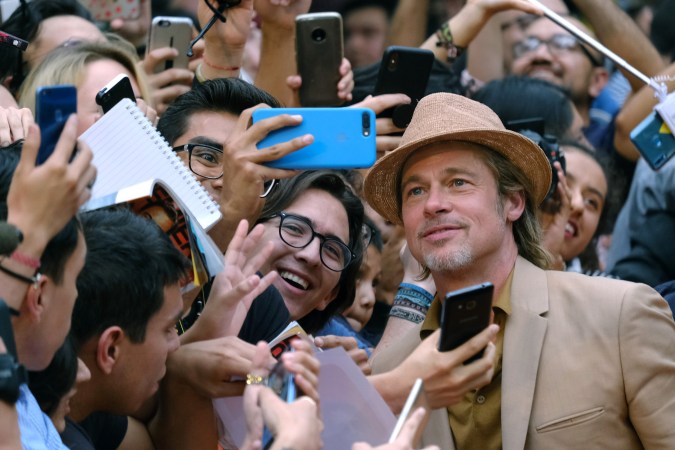 Brad Pitt posando en una alfombra roja.