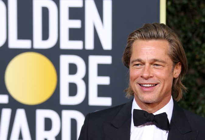 Brad Pitt posando en una alfombra roja.